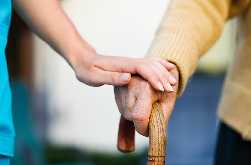 Doctor holding a senior patiens 's hand on a walking stick - special medical care concept for Alzheimer 's syndrome. ???????????